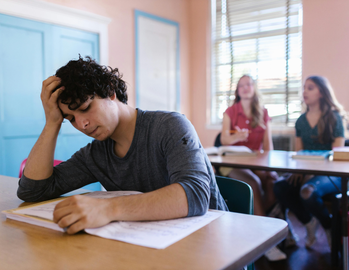 Boy reading text book in class Boy reading text book in class