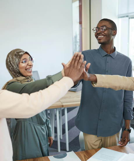 Diverse group of people smiliing and high-fiving each other Diverse group of people smiliing and high-fiving each other