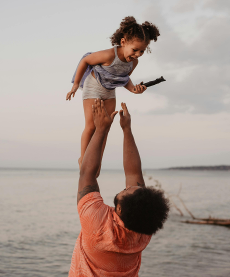 Fathering throwing young daughter in the air and catching her Fathering throwing young daughter in the air and catching her