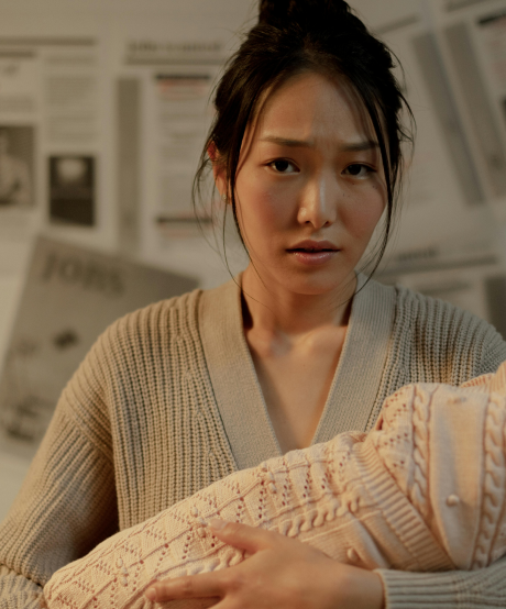 New mother holding her baby wrapped in a blanket New mother holding her baby wrapped in a blanket