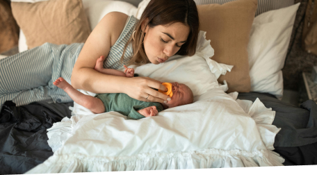 Mothing putting a pacifier in a new baby's mouth