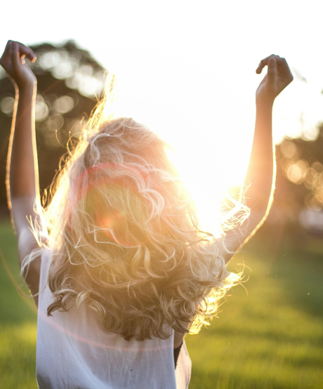 Women walking outside with her hands in the air taking in the sunrise Women walking outside with her hands in the air taking in the sunrise